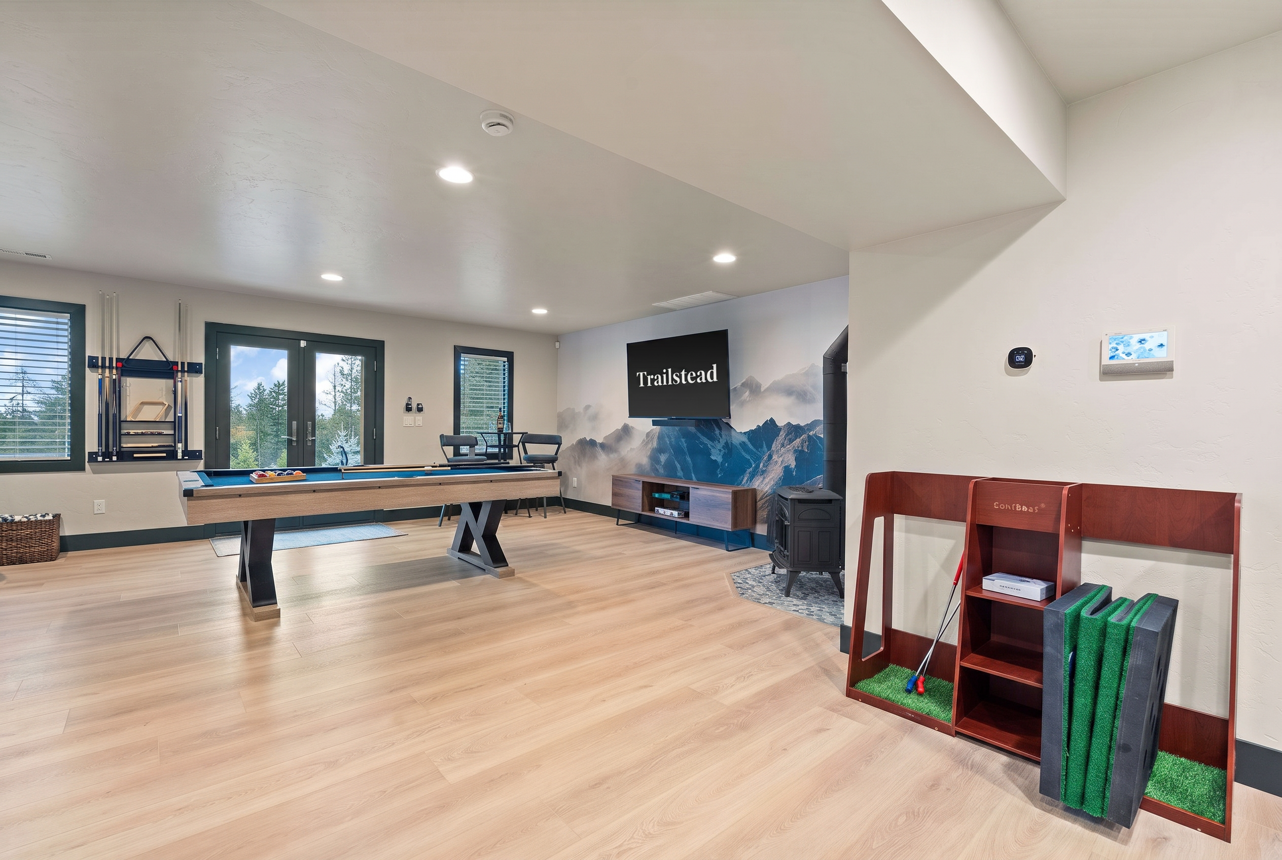 The Tamarack — game room with a pool table, wall-mounted television, mountain mural, and golf storage rack